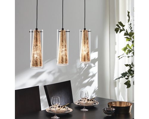 Taklampa EGLO Pinto 3-lågig längd 725mm guld Tre glaspendellampor hänger ovanför ett matbord.