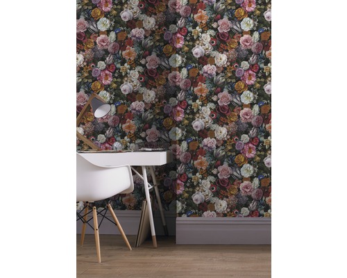 Scen med mönstrad tapet med blommotiv, skrivbord och stol.