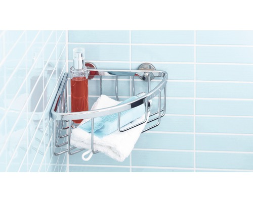 Hörnhylla i metall med vårdprodukter och handduk på en kakelvägg