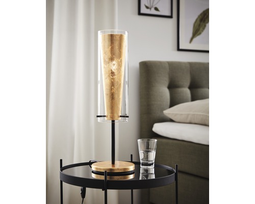 Dekorativ bordslampa med guldfärgad accent på nattduksbordet