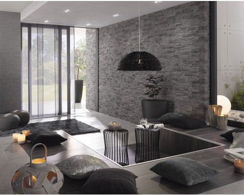 Modernt vardagsrum med skjutgardiner, stenmur och dekorativa element