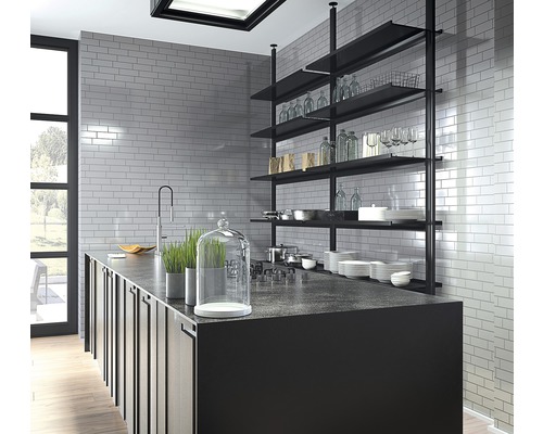 Ljust kök med köksö, hyllor och kakel