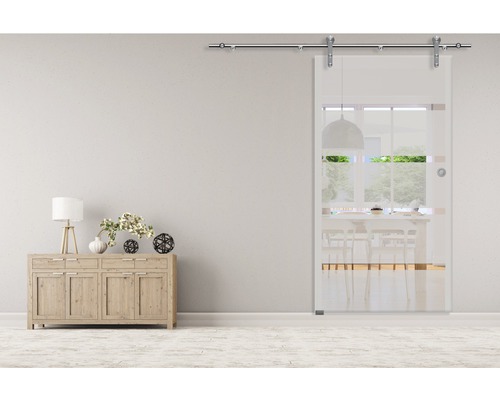 Scen med glasskjutdörr, byrå och dekorativa element i ett ljust rum.