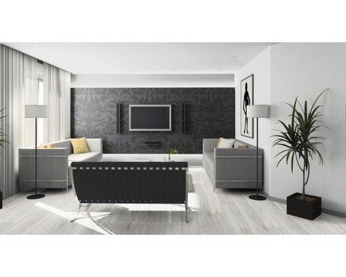 Ljust vardagsrum med soffa, fåtölj, golvlampa, krukväxt och tv