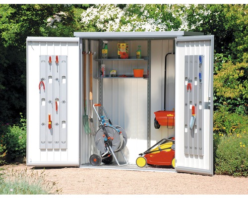 Öppet trädgårdsskjul med trädgårdsredskap och verktyg