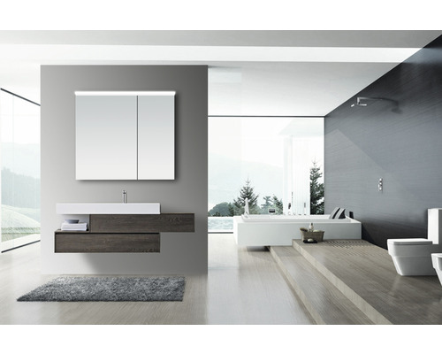 Modernt badrum med tvättställ, spegel, badkar och toalett