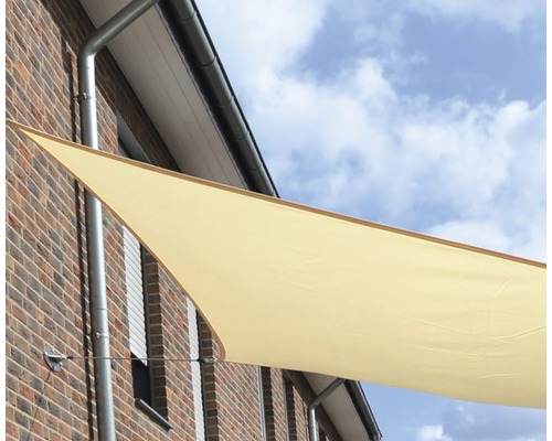 Triangulär solskydd monterad på en husvägg