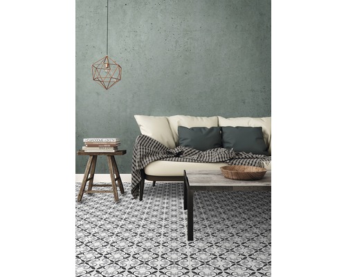 Vardagsrum med mönstrade plattor, soffa, bord och dekoration