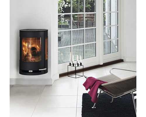 Vardagsrum med kamin, stol och ljusstake framför altandörren