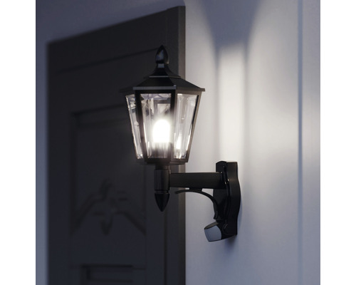Klassisk utomhusvägglampa med rörelsesensor bredvid en dörr
