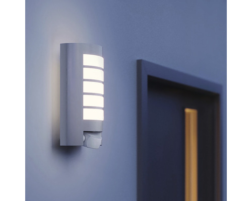 Vägglampa med rörelsesensor bredvid en dörr