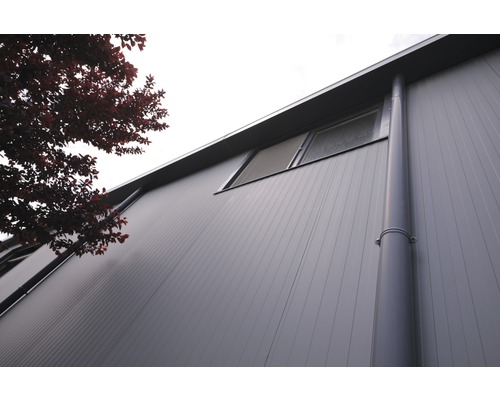 Vy mot av en fasad med fönster och stuprör