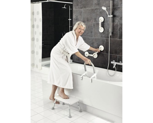Kvinna med badrock, badkarstege, pall och handtag i badrummet