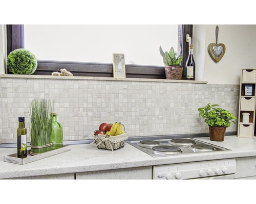 Köksscen med mosaikplattor på bakväggen och dekorationer på arbetsbänken.