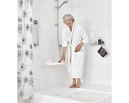 Badrum med duschpall, stödhandtag, duschdraperi och duschhuvud för en barriärfri duschupplevelse