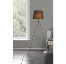 Golvlampa med svart lampskärm och stativben i ett vardagsrum