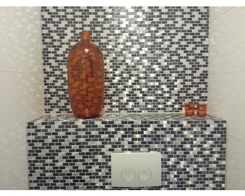 Dekorativ glasmosaikvägg med brun vas och toalettspolning