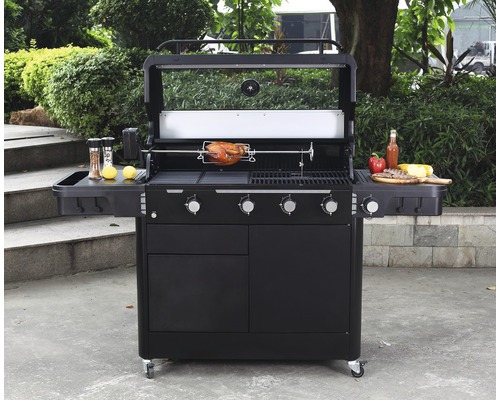 Svart gasolgrill med rotisseri och tillbehör på sidobord i trädgården.