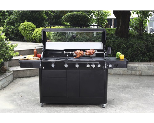 Stor grill med roterande grillspett, grillad mat och förvaringsutrymmen utomhus