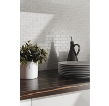 Scen med mosaikplattor i tegeldesign, bänkskiva, porslin och dekoration