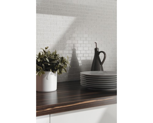 Scen med mosaikplattor i tegeldesign, bänkskiva, porslin och dekoration