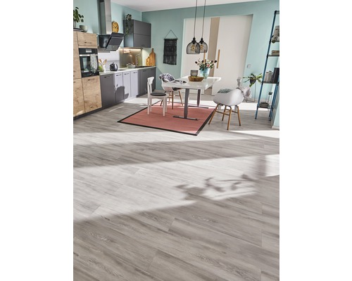 Ljust kök med matbord, stolar och laminatgolv.