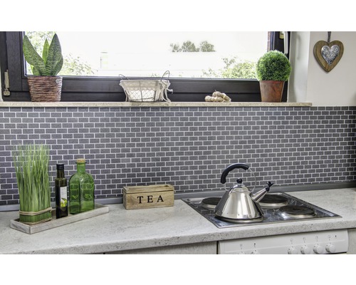 Köksscen med mosaikplattor, spishäll, tekanna och dekoration