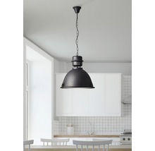 Svart hänglampa ovanför ett matbord i ett ljust kök.