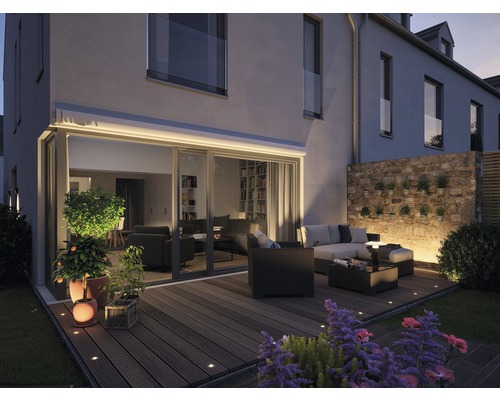 Terrass med trädgårdsmöbler och belysning vid huset