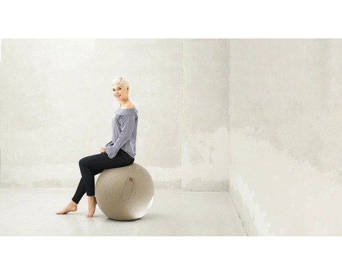 Kvinna sitter på en gymnastikboll i ett ljust rum.