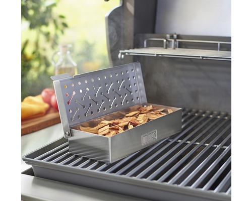 Grill med rökbox fylld med rökflis på grillgaller