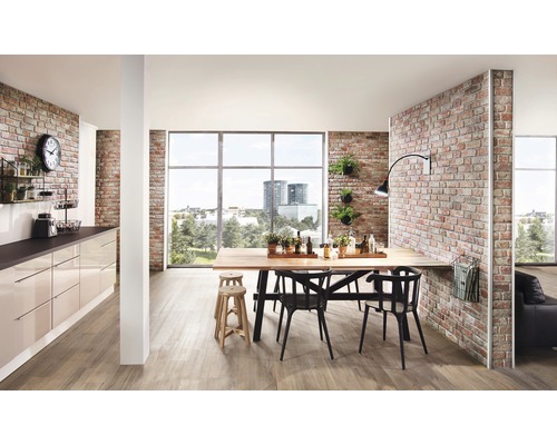 Ljust vardagsrum med matbord, stolar, pentry och tegelvägg