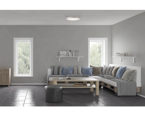 Vardagsrum med soffa av pallar, träbord och taklampa