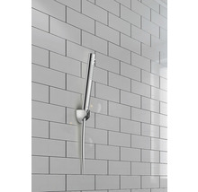 Handdusch med vägghållare framför kakelvägg