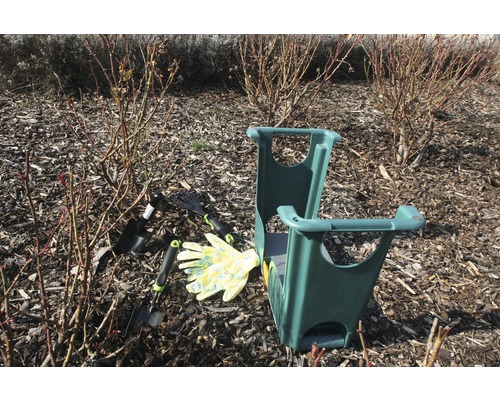 Trädgårdsscen med knäbänk, trädgårdsredskap och trädgårdshandskar