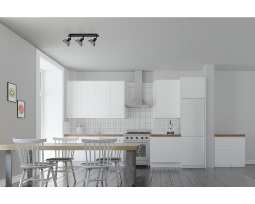 Ljust vardagsrum med kök, matbord och stolar