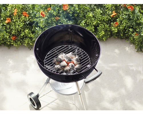 Rund grill med glödande träkol på grillgaller