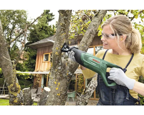 Kvinna beskär träd med en tigersåg från Bosch.