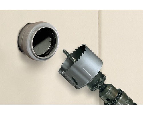 Hålsåg på en borrmaskin bredvid en vägggenomföring