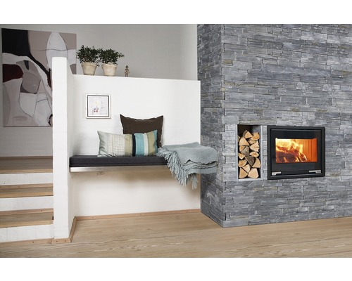 Vardagsrum med stenmur, öppen spis, vedträn och sittbänk