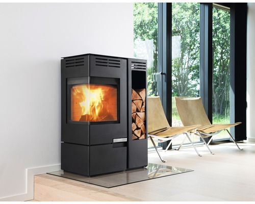 Modern braskamin med vedfack och golvplatta i glas i ett ljust rum.