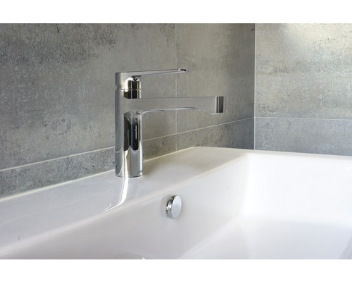 Bild av en diskbänksblandare i metall på ett tvättställ