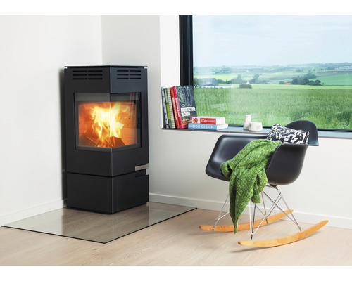 Braskamin i vardagsrum med fåtölj och fönster