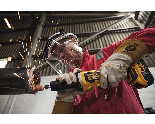 Man slipar metallrör med DeWalt batteridriven rak slipmaskin, gnistor flyger.