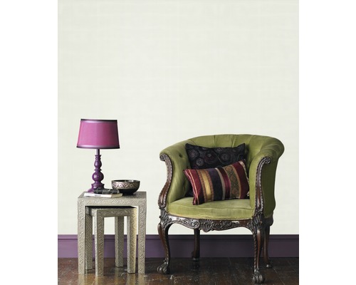 Interiörbild av ett vardagsrum med fåtölj, bord och lampa