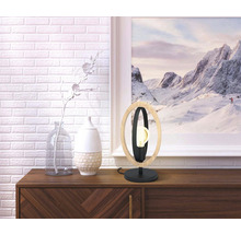 Dekorativ bordslampa av trä och metall på en skänk