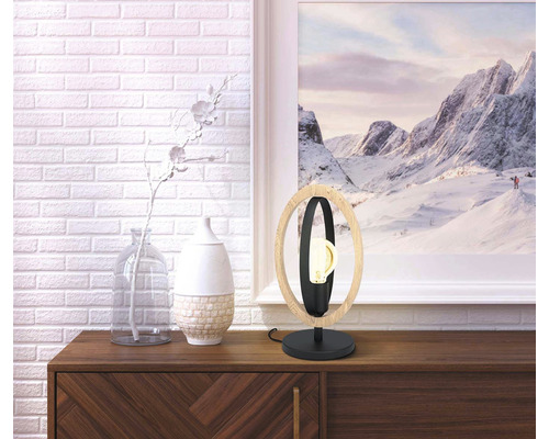 Dekorativ bordslampa av trä och metall på en skänk