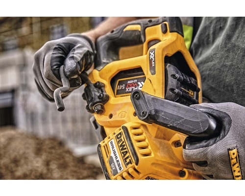 Närbild på en DeWalt sladdlös betongspikpistol med en operatör i handskar som håller i en spik
