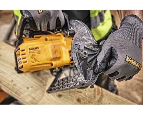 En Dewalt handsåg används av en person med Dewalt arbetshandskar för att såga trä.