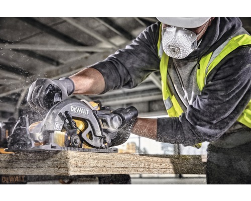 En arbetare sågar en träbräda med en DeWalt handhållen cirkelsåg.